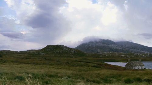 Scenic view of mountains against cloudy sky