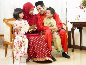 Family sitting on sofa at home during celebration