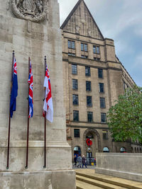 Low angle view of flags on street amidst buildings in city