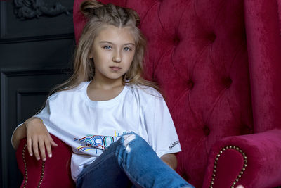 Portrait of girl sitting on sofa