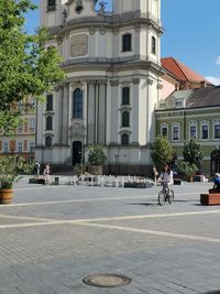 People on street against buildings in city