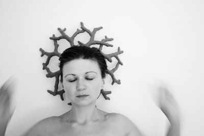 Portrait of young woman against wall