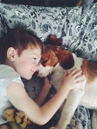 Cute boy with dog relaxing at home