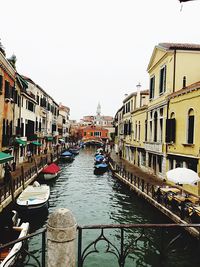 Boats in canal along buildings