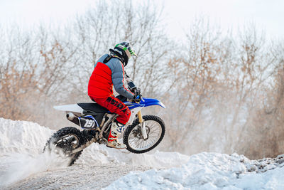 Man riding bicycle on snow covered field