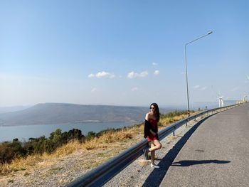 Full length of woman on road against sky