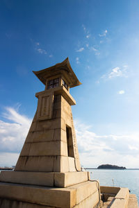 Low angle view of building by sea against sky