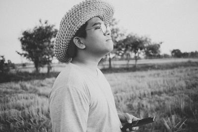 Portrait of man wearing hat standing on field