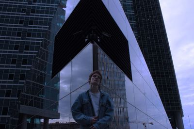 Low angle view of woman against modern buildings