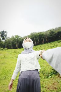 Rear view of woman standing on field