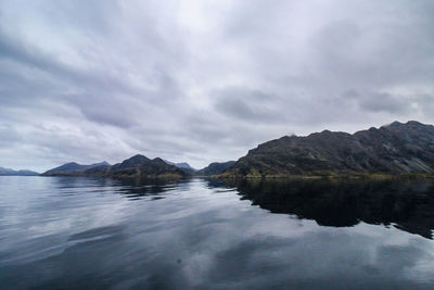 Scenic view of lake by mountains against sky