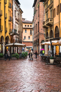 People on street by buildings in city