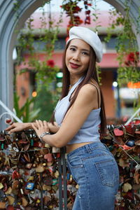 Portrait of woman standing by padlocks in city