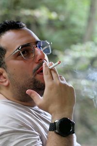 Portrait of young man smoking cigarette