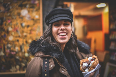 Portrait of smiling young woman using smart phone during winter