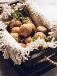 Baby potato in wooden brown box with napkin and rosemary