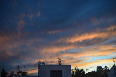 Low angle view of silhouette buildings against sky during sunset