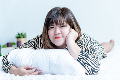 Portrait of teenage girl lying on bed