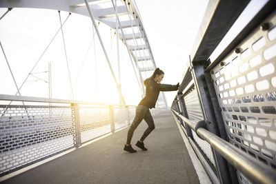 Side view of young man on bridge