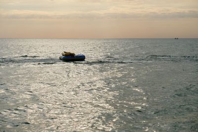 Boat on sea against sky during sunset