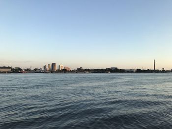 Scenic view of river by city against clear sky