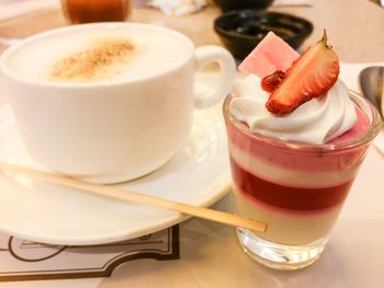 Close-up of coffee and dessert served on table