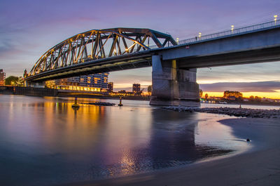 View of bridge over river at sunset