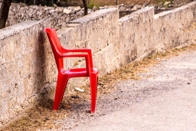 Close-up of red chair on table against wall