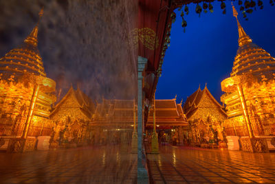 Illuminated buildings in temple against sky