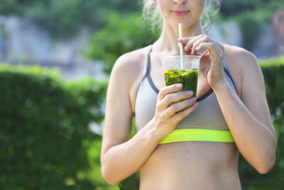 Midsection of woman drinking drink