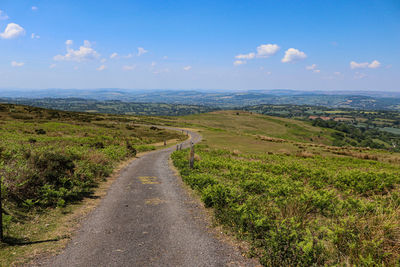 Road leading towards mountains against sky