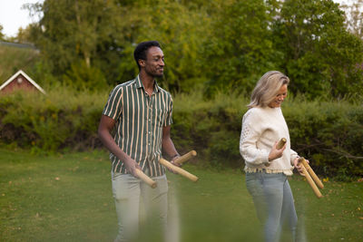 Man and woman playing molkky game in park