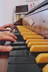 Cropped hands of person playing piano