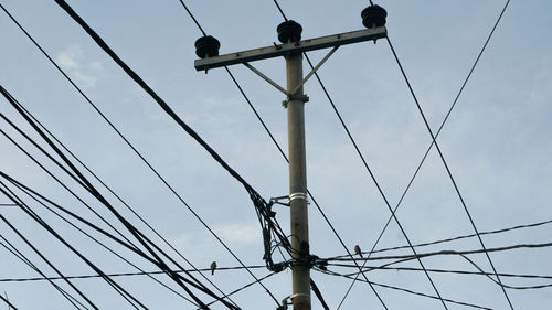 Low angle view of electricity pylon against clear sky