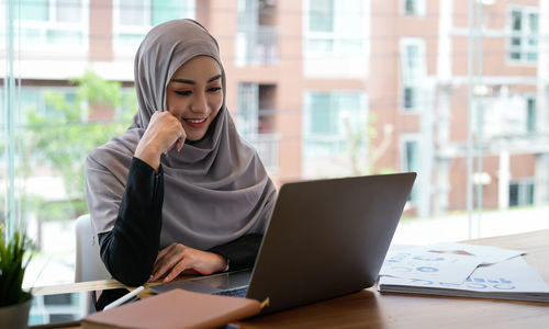 Businesswoman using laptop at office