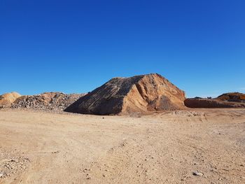 Scenic view of desert against clear blue sky