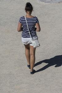 Rear view of woman walking on footpath