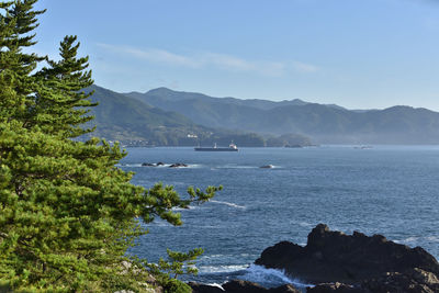 Scenic view of sea and mountains against sky