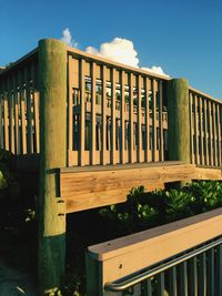 Wooden boardwalk at beach against sky