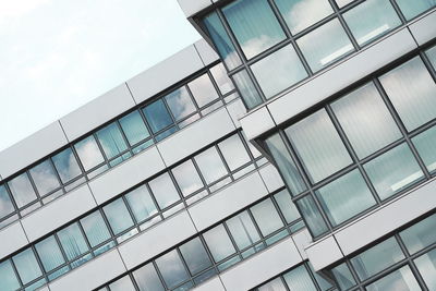 Low angle view of modern glass building against sky