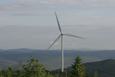 Windmill on mountain against sky