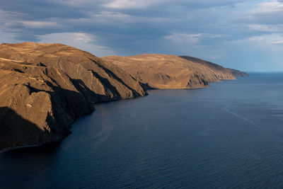 Rock formations by sea against sky