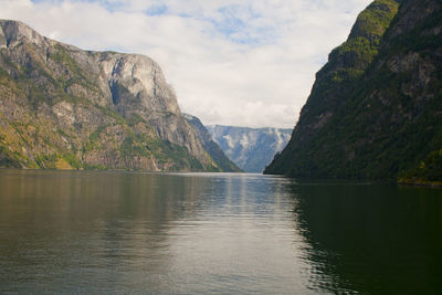 Scenic view of lake by mountains against sky