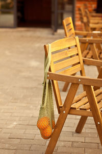 Empty chairs and table on footpath against building