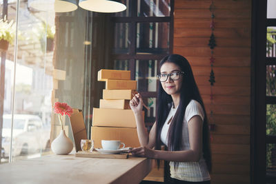 Portrait of smiling young woman at table