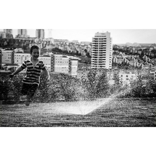 lifestyles, building exterior, leisure activity, architecture, built structure, full length, casual clothing, person, city, young adult, standing, clear sky, water, young men, cityscape, boys, side view