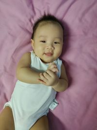 High angle view of baby girl lying on bed