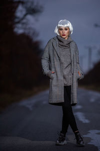 Full length portrait of woman standing in snow