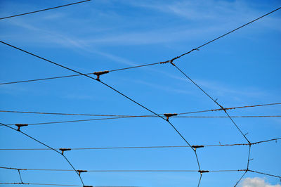 Low angle view of power lines against blue sky