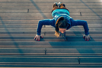 High angle view of young woman exercising on promenade during sunset